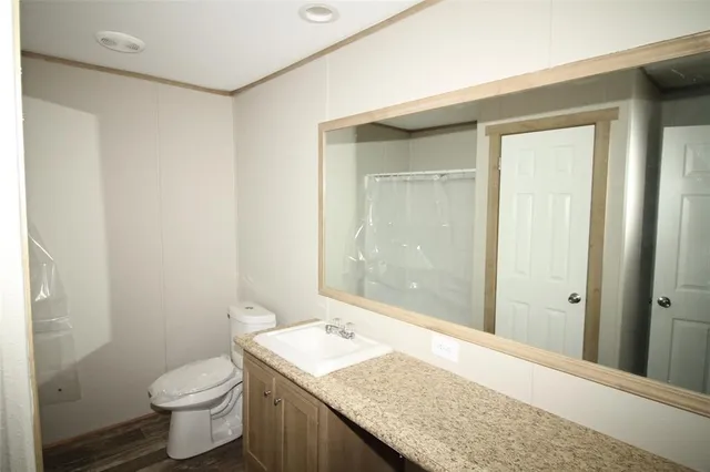 a bathroom with a granite countertop sink toilet and shower