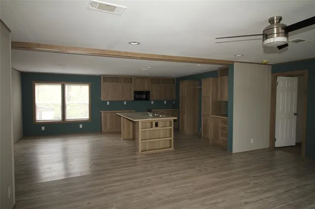 a view of kitchen with sink microwave and cabinets
