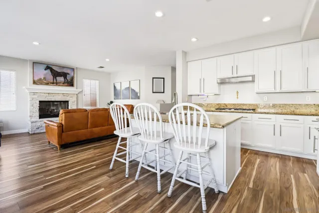 a kitchen with granite countertop a refrigerator stove top oven and sink