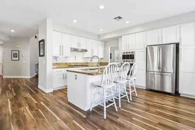 a kitchen with kitchen island granite countertop a stove and a refrigerator