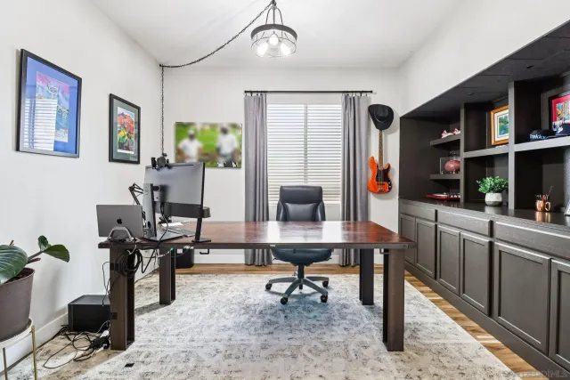 a living room with furniture a piano and a bookshelf