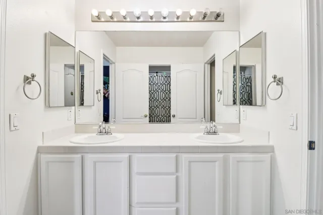 a bedroom with a bed and a flat tv screen on dresser