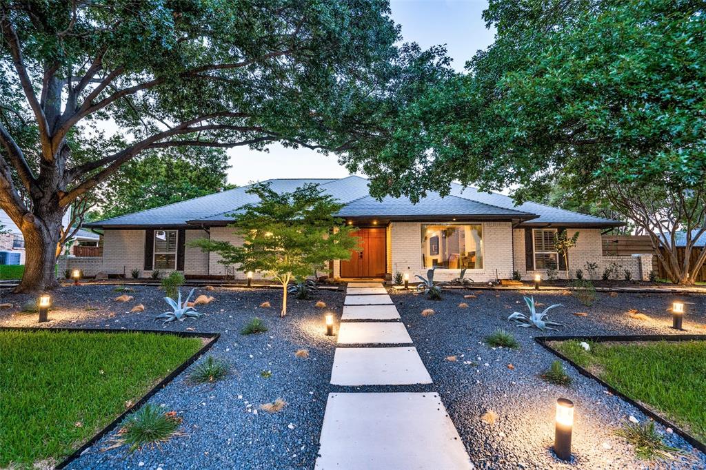 a view of a yard with a table and chairs under an umbrella