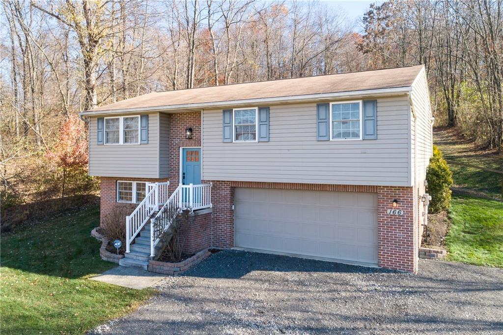 166 Country Club Road Washington, PA 15301 - Photo 2 of 32 a front view of a house with a yard and garage