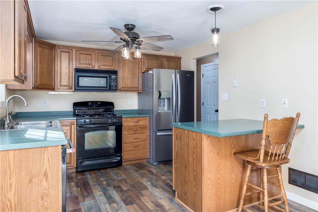 166 Country Club Road Washington, PA 15301 - Photo 9 of 32 a kitchen with stainless steel appliances granite countertop a stove top oven a sink dishwasher a dining table and chairs with wooden floor