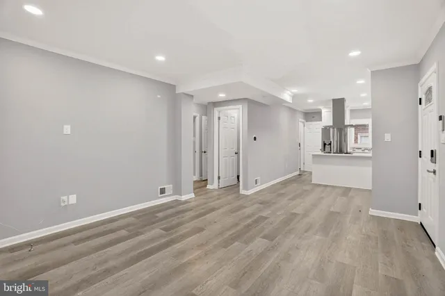 a kitchen with kitchen island stainless steel appliances a sink and wooden floor