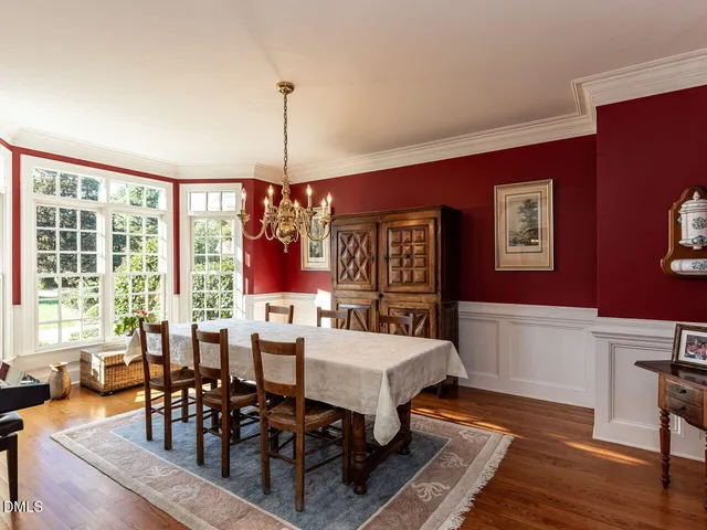 a view of a big room with table chairs and a backyard