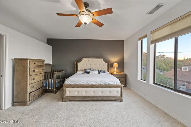 a spacious bedroom with a bed and a large window