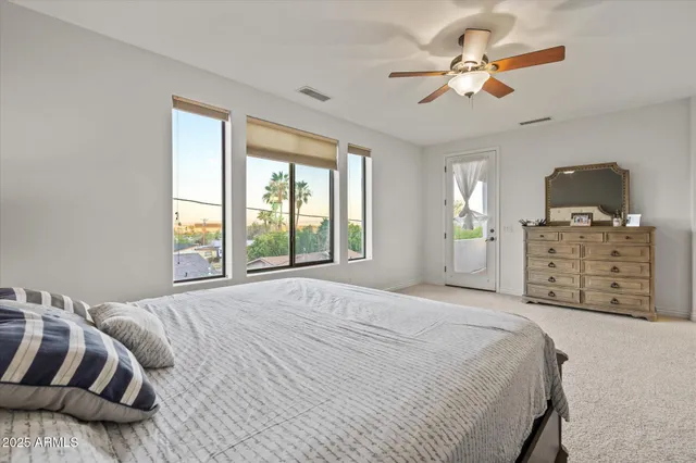 a spacious bedroom with a bed a chandelier and a window