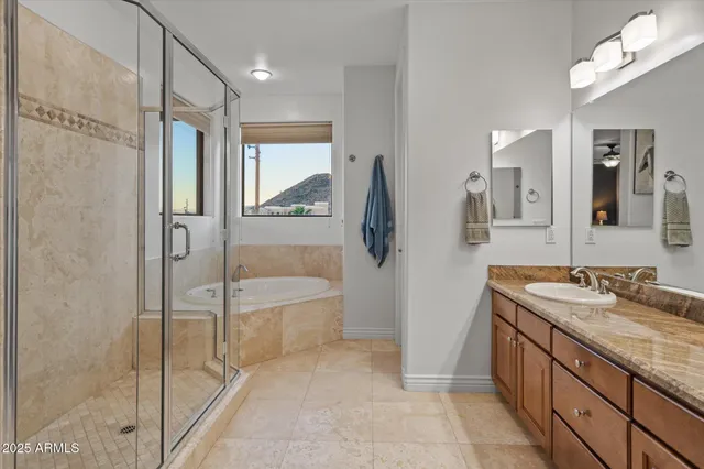 a spacious bathroom with a granite countertop sink a mirror and a shower