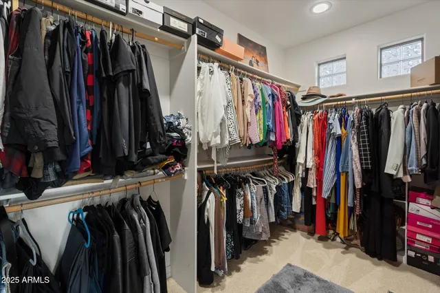 a view of walk in closet with clothes