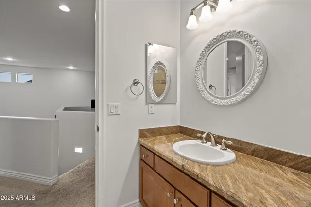 a bathroom with a granite countertop double vanity sink and a mirror