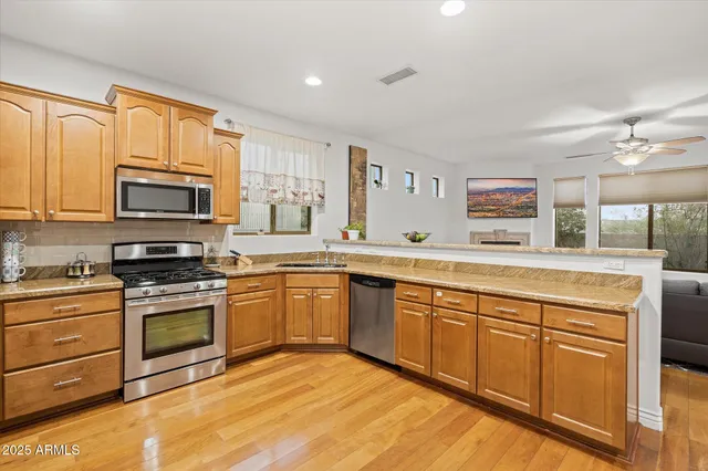 a kitchen with stainless steel appliances granite countertop a stove a sink and a microwave
