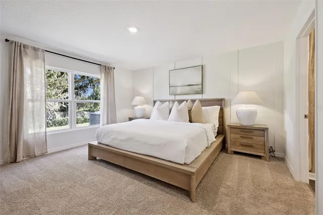 a spacious bedroom with a bed and a window