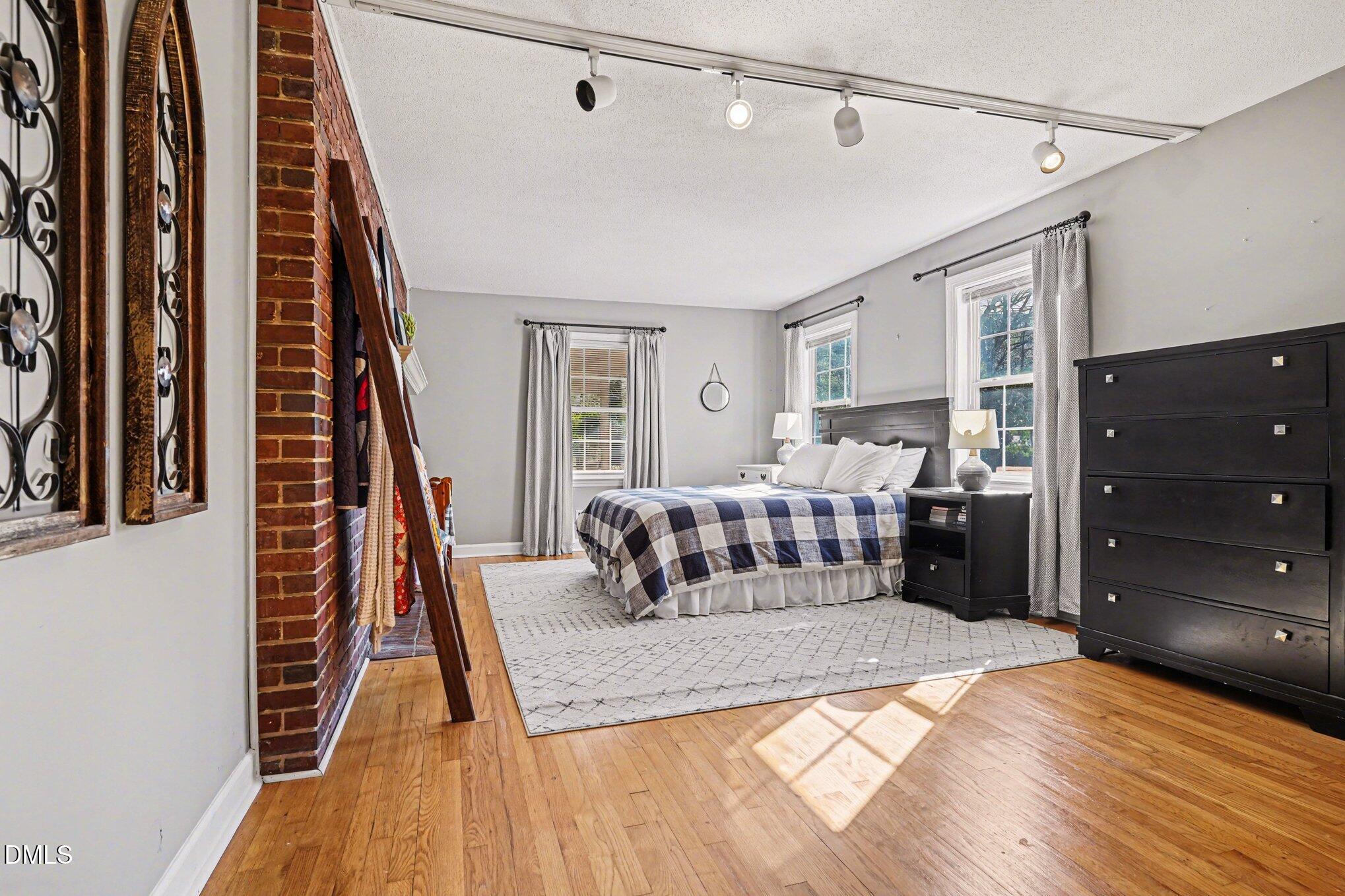3400 Octavia Street Raleigh, NC 27606 - Photo 18 of 36 a bedroom with a bed and wooden floor