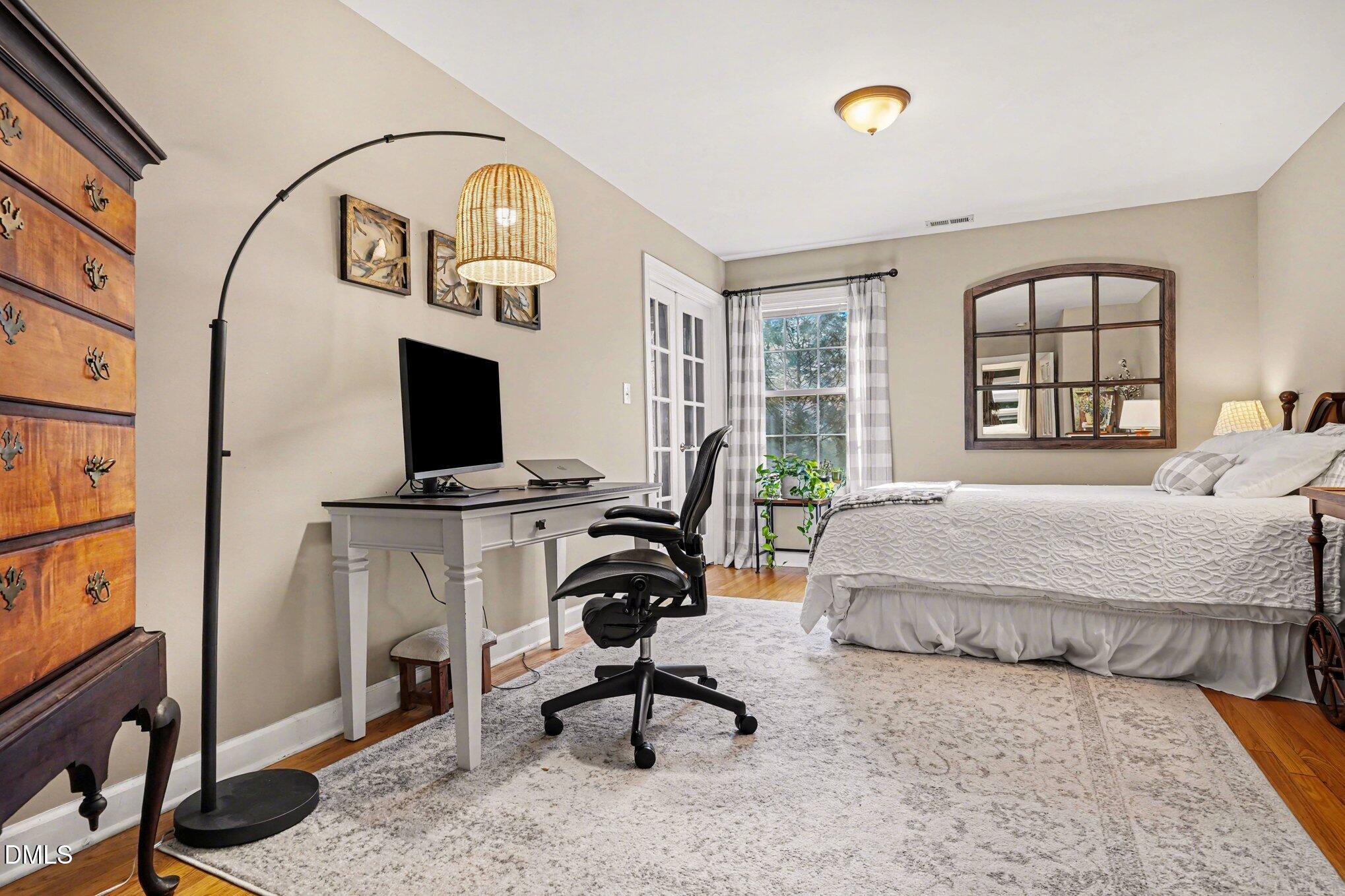 3400 Octavia Street Raleigh, NC 27606 - Photo 20 of 36 a bedroom with a bed a flat screen tv and windows