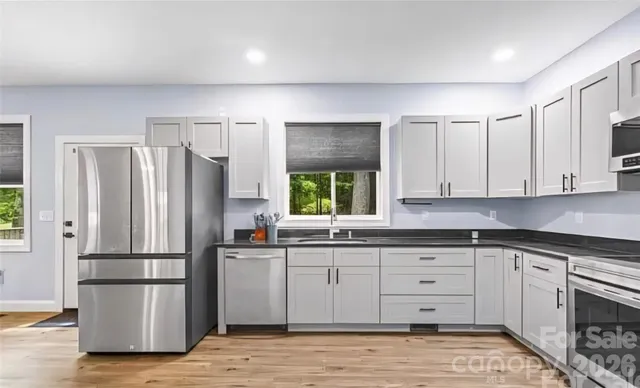 a kitchen with a refrigerator sink and cabinets