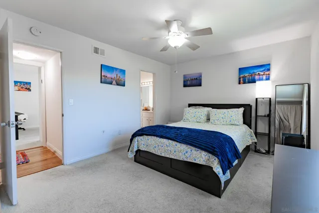 a spacious bedroom with a bed and a chandelier