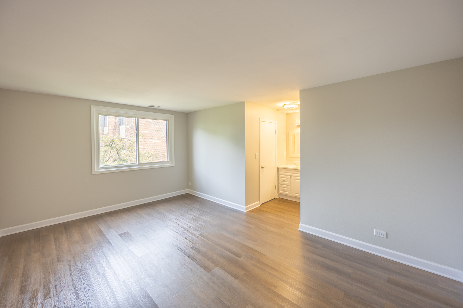 450 Raintree Court, Unit 2B Glen Ellyn, IL 60137 - Photo 13 of 28 an empty room with wooden floor and windows