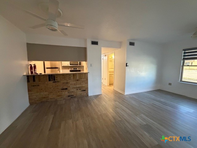 508 East Travis Street Luling, TX 78648 - Photo 3 of 17 wooden floor in an empty room with a window