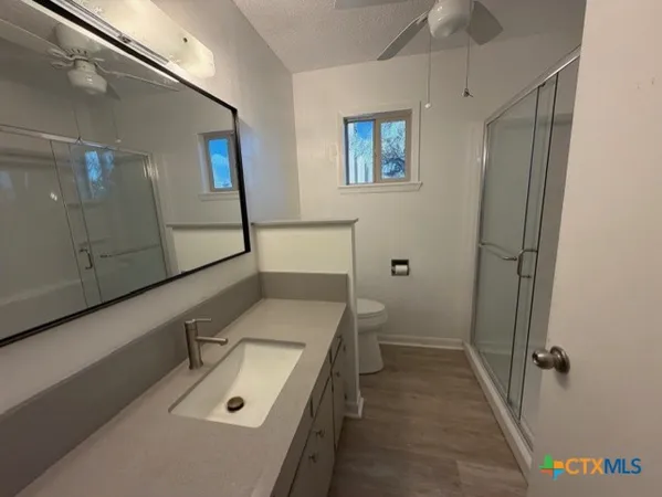 a bathroom with a sink a toilet and shower