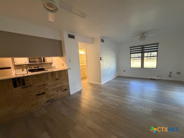 508 East Travis Street Luling, TX 78648 - Photo 8 of 17 an empty room with wooden floor and windows