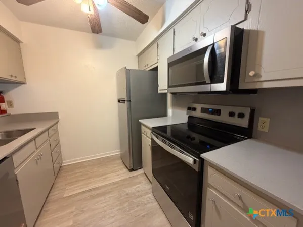 a kitchen with stainless steel appliances a stove a microwave and a sink