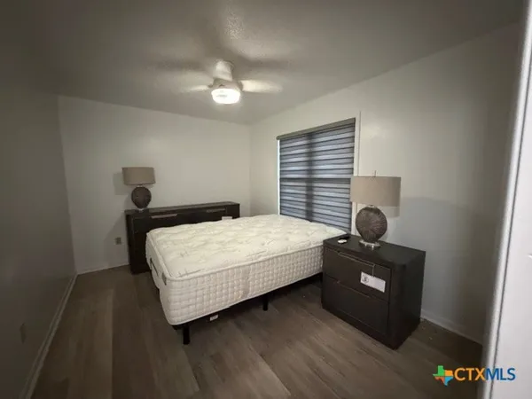 a bedroom with a bed and a lamp on desk