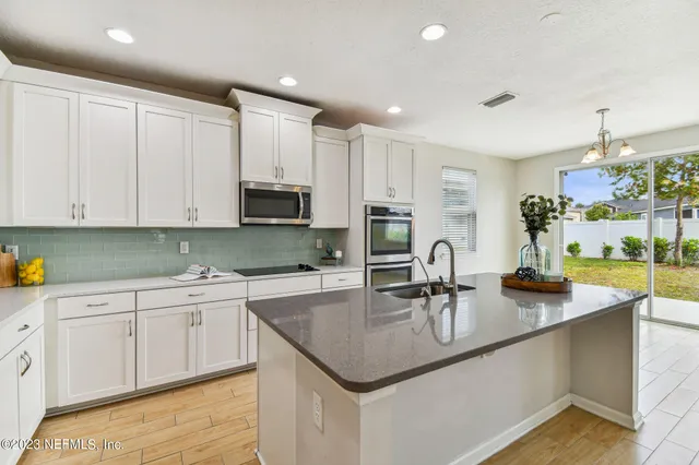 a kitchen with kitchen island a sink and wooden floor
