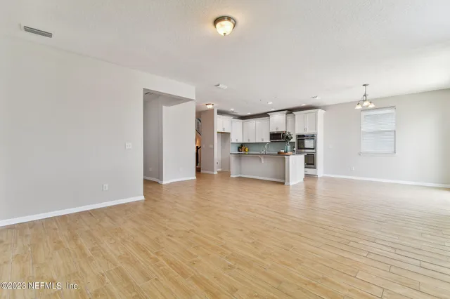 a view of a room with wooden floor closet and front door