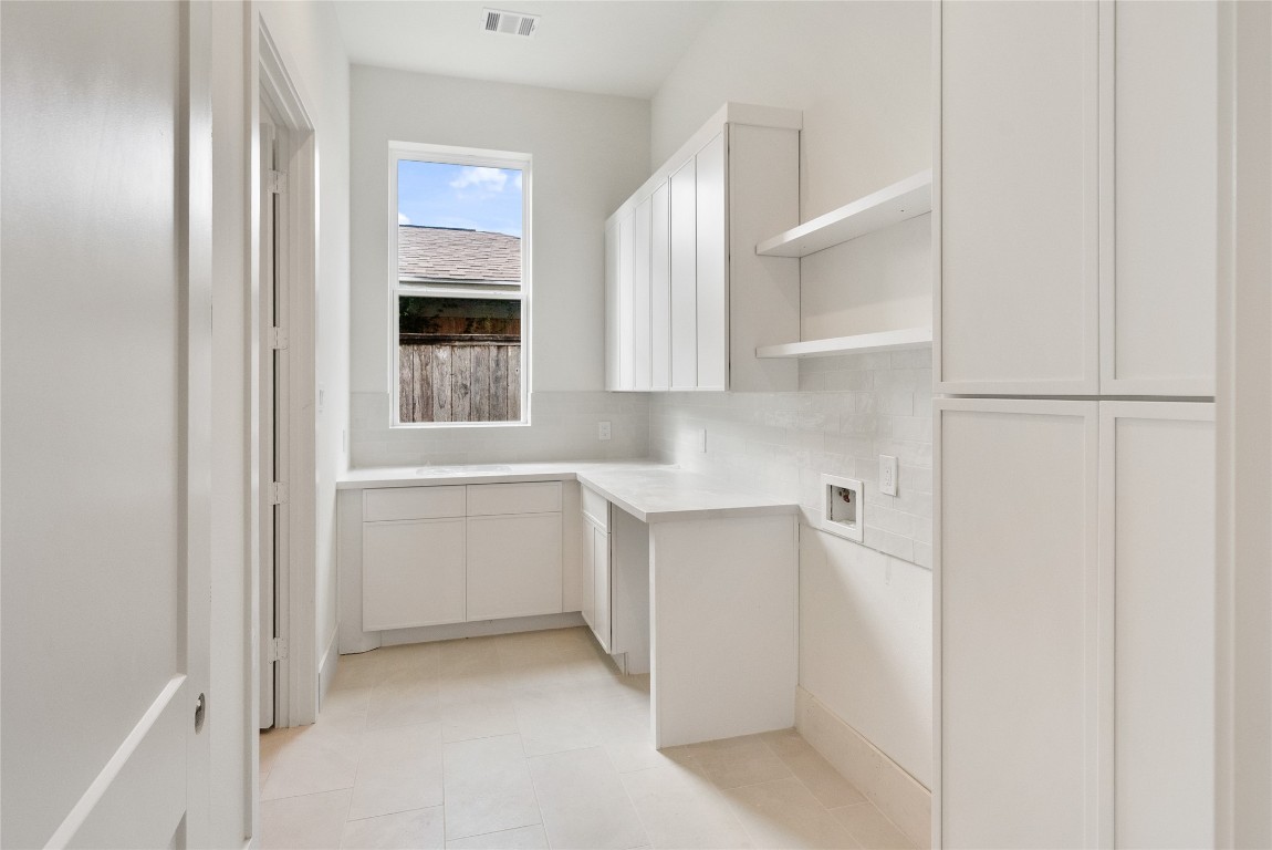 1002 East 25th Street Houston, TX 77009 - Photo 29 of 45 a kitchen with white cabinets and white appliances