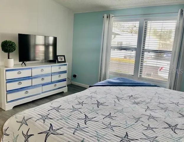 a bedroom with a bed and a flat screen tv