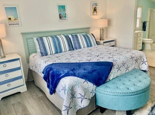 a bed sitting in a bedroom next to a cabinet and a mirror