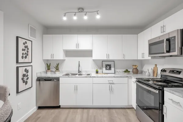 a kitchen with stainless steel appliances granite countertop a sink and cabinets