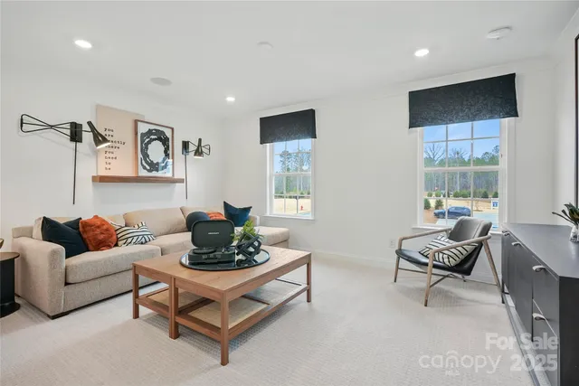 a bedroom with a bed wooden floor and a large window