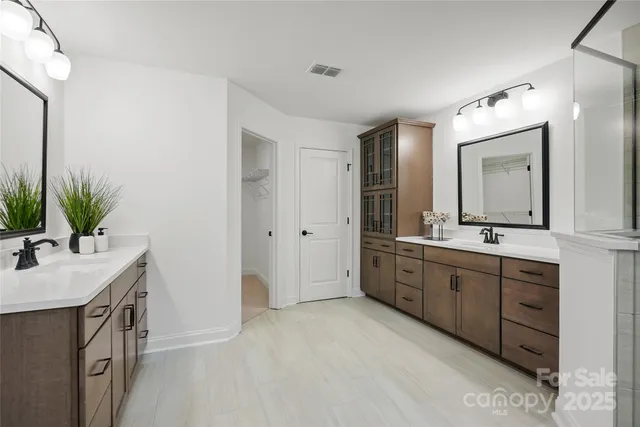 a spacious bathroom with a double vanity sink mirror and bathtub