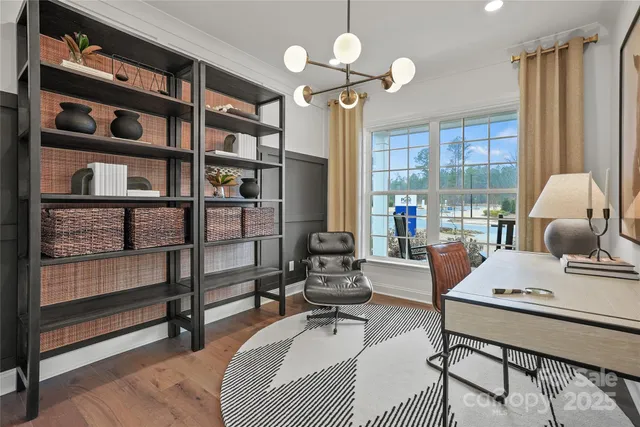 a living room with furniture a flat screen tv and a floor to ceiling window