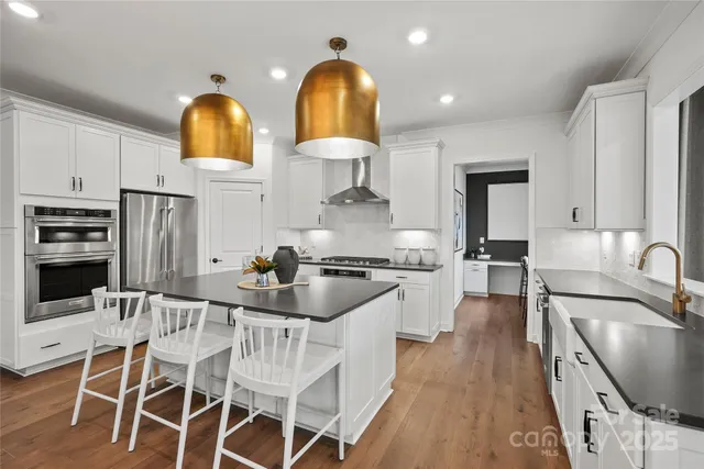 a kitchen with stainless steel appliances a stove a sink a microwave and dining table