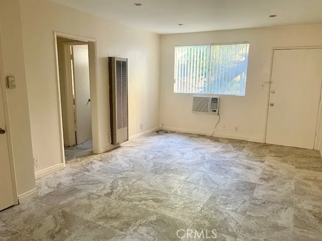 an empty room with wooden floor and a window