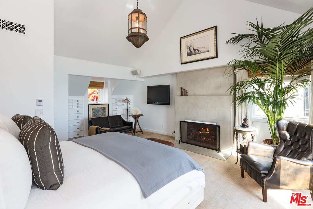 21644 Pacific Coast Highway Malibu, CA 90265 - Photo 46 of 53 a bedroom with a bed and a fireplace