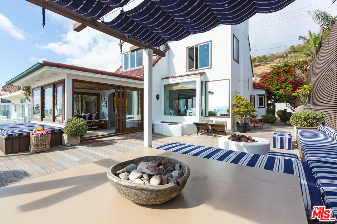 21644 Pacific Coast Highway Malibu, CA 90265 - Photo 6 of 53 a view of a patio with a dining table and chairs with a fire pit