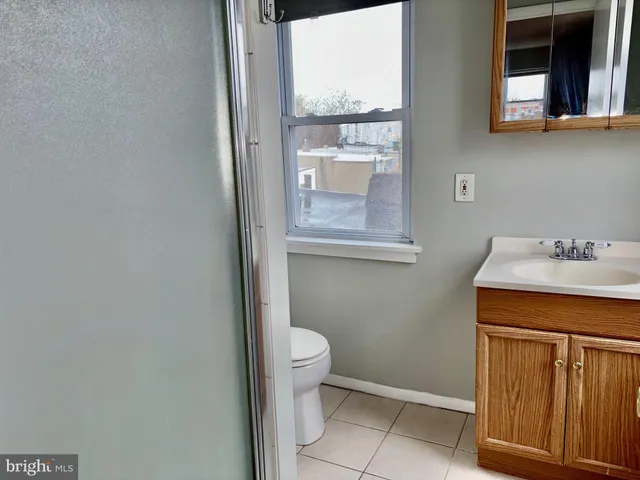 a bathroom with a sink a toilet and a window