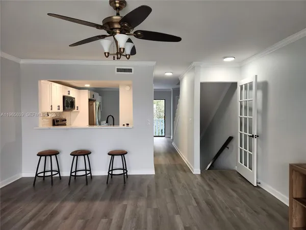a view of a dining room with furniture a chandelier and wooden floor