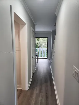 a view of a hallway with wooden floor and windows