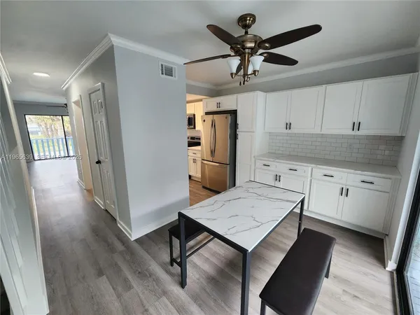 a kitchen with kitchen island a wooden floor and white appliances