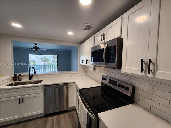 a kitchen with stainless steel appliances granite countertop a sink and a stove