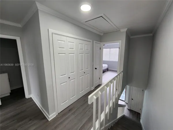 a view of a hallway with wooden floor and staircase
