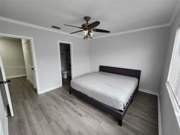a bedroom with a bed and a ceiling fan