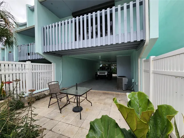 a view of a chairs and table in backyard of the house
