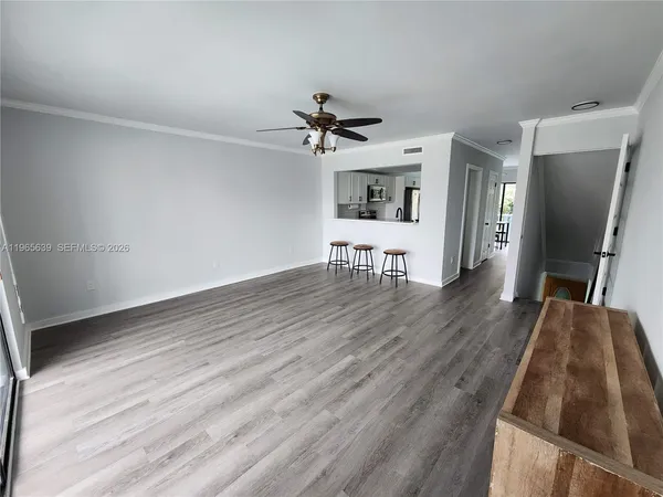 a view of a kitchen with wooden floor and a ceiling fan